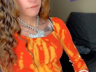 Stroking her cock in an orange croptop